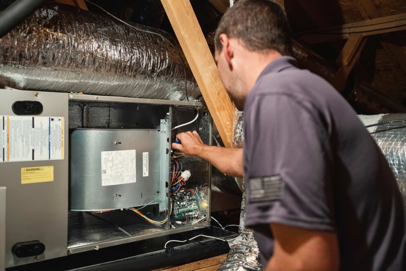 Indoor Climate Experts | Technician servicing HVAC system